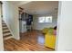 Bright living room with hardwood floors, stairs, and a comfortable yellow sofa at 4328 S Carr Ct, Littleton, CO 80123