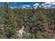 Aerial view of a home nestled within a lush green forest, surrounded by tall trees at 1410 Old Sequoia Ct, Franktown, CO 80116