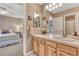 Bathroom with sink and view of bedroom with bed, carpet, and furniture at 1410 Old Sequoia Ct, Franktown, CO 80116