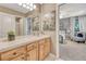 Bathroom featuring double sinks, wood drawers, mirrors, and carpet flooring at 1410 Old Sequoia Ct, Franktown, CO 80116