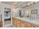 Bathroom with double sinks, wood drawers, mirrors, and tile flooring at 1410 Old Sequoia Ct, Franktown, CO 80116