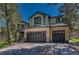 Inviting two-story home with a stone facade and attached three-car garage at 1410 Old Sequoia Ct, Franktown, CO 80116
