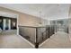 Second floor hallway featuring dark wood railings and natural light from the window at 1410 Old Sequoia Ct, Franktown, CO 80116