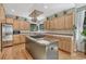 Well-lit kitchen with stainless steel appliances, a center island, and hardwood floors at 1410 Old Sequoia Ct, Franktown, CO 80116