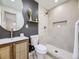 Modern bathroom with gray accent wall, an oval mirror, and a tiled step-in shower at 920 S Hudson St, Denver, CO 80246