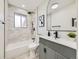 Modern bathroom with gray tiled walls, updated vanity and new black fixtures at 920 S Hudson St, Denver, CO 80246