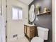 Modern bathroom with gray accent wall, an oval mirror, and a stylish vanity at 920 S Hudson St, Denver, CO 80246