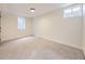 A bright, carpeted bedroom featuring two basement windows allowing for natural light at 920 S Hudson St, Denver, CO 80246