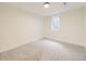 A cozy, carpeted bedroom featuring a window allowing for natural light at 920 S Hudson St, Denver, CO 80246