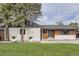Charming home with a manicured lawn, trees, and updated exterior featuring light colored brick and modern design accents at 920 S Hudson St, Denver, CO 80246