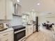 Modern kitchen with white cabinets, stainless steel appliances, and open layout connected to the dining area at 920 S Hudson St, Denver, CO 80246