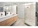 Modern bathroom with a double sink vanity and a glass-enclosed shower featuring textured tile walls at 720 S Clayton St, Denver, CO 80209
