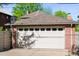A detached brick garage with a white door adds convenience and storage to this charming home at 720 S Clayton St, Denver, CO 80209