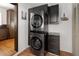 Modern laundry room with stacked washer and dryer, sleek cabinetry, and hardwood flooring at 720 S Clayton St, Denver, CO 80209