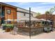 Outdoor seating at a restaurant with striped umbrellas and wooden fencing in the Bonnie Brae neighborhood at 720 S Clayton St, Denver, CO 80209