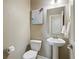Cozy powder room features pedestal sink, white fixtures and simple decor at 15275 W La Salle Ave, Lakewood, CO 80228