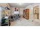 A well-lit home office boasts a modern desk, shelving, and a bookcase with a view of the staircase at 15275 W La Salle Ave, Lakewood, CO 80228