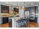 Modern kitchen with stainless steel appliances, dark cabinetry, and a large center island with seating at 15275 W La Salle Ave, Lakewood, CO 80228