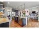 Open-concept kitchen featuring granite countertops, stainless steel appliances, and hardwood floors at 15275 W La Salle Ave, Lakewood, CO 80228