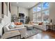 Bright living room featuring a stone fireplace, hardwood floors, and ample natural light at 15275 W La Salle Ave, Lakewood, CO 80228