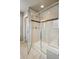 Modern shower with glass doors, bench, and tiled walls with decorative accent tiles at 15275 W La Salle Ave, Lakewood, CO 80228