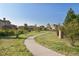 Sidewalk walking path through a landscaped neighborhood lined with trees and green grass at 15275 W La Salle Ave, Lakewood, CO 80228