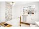 Beautiful bathroom featuring a white tub, hexagon tile accent wall, gold hardware, and natural light from a glass block window at 5055 W 33Rd Ave, Denver, CO 80212