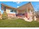 Inviting brick home with a red tile roof, well-manicured lawn, and charming front porch with seating at 5055 W 33Rd Ave, Denver, CO 80212