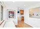 Bright hallway with white walls, wood floors, art and a cabinet at 5055 W 33Rd Ave, Denver, CO 80212