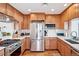 Bright kitchen features stainless steel appliances, light countertops, and wooden cabinets at 5055 W 33Rd Ave, Denver, CO 80212