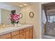 Bathroom with double sinks, granite countertops, and a glass-enclosed shower for a spa-like experience at 7649 Pineridge Ter, Castle Pines, CO 80108