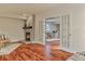 Bright living room showing a fireplace, wood floors and french doors to another living space at 7649 Pineridge Ter, Castle Pines, CO 80108