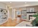 Spacious living room with hardwood floors, a fireplace, built-in shelves, and natural light from large windows at 7649 Pineridge Ter, Castle Pines, CO 80108