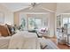 Bright and airy main bedroom featuring a cozy seating area, a ceiling fan, and ample natural light at 7649 Pineridge Ter, Castle Pines, CO 80108