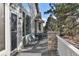 Relaxing outdoor porch with chairs, stone pillars, and a view of the surrounding nature at 7649 Pineridge Ter, Castle Pines, CO 80108
