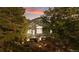 Rear exterior view of the home with a spacious deck nestled amongst lush greenery, and mature trees at 7649 Pineridge Ter, Castle Pines, CO 80108