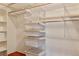 Organized walk-in closet with wooden trim and wire shelving, providing ample storage and organization space at 7649 Pineridge Ter, Castle Pines, CO 80108