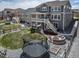 Aerial view of a large backyard featuring a trampoline, fire pit, patio seating, and well-maintained lawn at 23879 E Narrowleaf Pl, Aurora, CO 80016