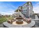 Spacious backyard featuring a fire pit area with seating, a two-story home and a lush lawn at 23879 E Narrowleaf Pl, Aurora, CO 80016