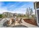 Backyard haven with a fire pit surrounded by comfortable seating, a playhouse, and mature landscaping at 23879 E Narrowleaf Pl, Aurora, CO 80016