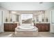 Luxurious bathroom featuring dual vanities, a soaking tub, and a large window with neighborhood views at 23879 E Narrowleaf Pl, Aurora, CO 80016