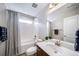 Clean bathroom featuring shower-over-tub, dark wood vanity and a large mirror above the sink at 23879 E Narrowleaf Pl, Aurora, CO 80016
