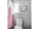 Bright bathroom featuring a toilet with a colorful shower curtain and a cute wall decor at 23879 E Narrowleaf Pl, Aurora, CO 80016