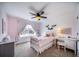 Bright bedroom featuring a charming white bed frame, ceiling fan, and ample natural light from the window at 23879 E Narrowleaf Pl, Aurora, CO 80016
