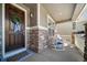 Inviting front porch with stone accents, rocking chairs, and a charming wreath on the front door at 23879 E Narrowleaf Pl, Aurora, CO 80016