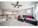 Comfortable upstairs loft with a plush sectional, carpet flooring, modern ceiling fan, and staircase view at 23879 E Narrowleaf Pl, Aurora, CO 80016