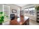 Office space featuring a large wooden desk, multiple windows, and comfortable seating at 23879 E Narrowleaf Pl, Aurora, CO 80016