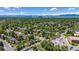 Beautiful aerial view of a neighborhood featuring lush green trees and a mountain range in the background at 8272 Ammons Cir, Arvada, CO 80005