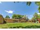 Sprawling backyard features mature trees, lush lawn, a wooden fence, and a playset at 8272 Ammons Cir, Arvada, CO 80005