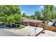 Charming brick home with a well-maintained lawn, mature trees, and a spacious driveway at 8272 Ammons Cir, Arvada, CO 80005